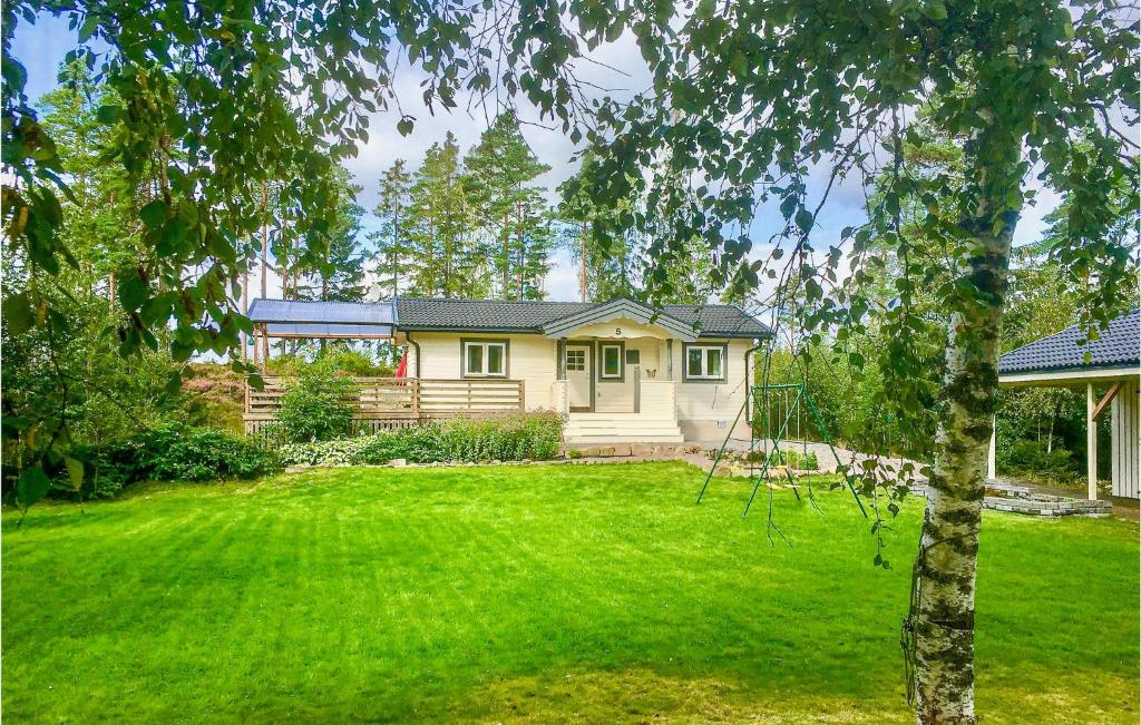 une maison dans une cour avec une pelouse verte dans l'établissement Awesome Home In Frgelanda With 2 Bedrooms, à Muberg