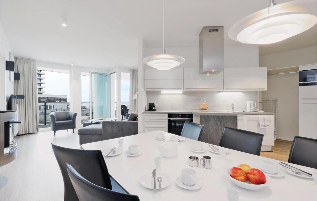 Il comprend une cuisine et une salle à manger avec une table et des chaises blanches. dans l'établissement Amazing Apartment In Lbeck Travemnde With Kitchen, à Travemünde