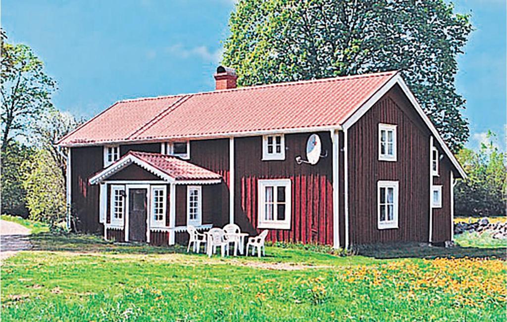 Maison rouge et blanche avec une table et des chaises dans l'établissement Beautiful Home In Linneryd With Kitchen, à Linneryd