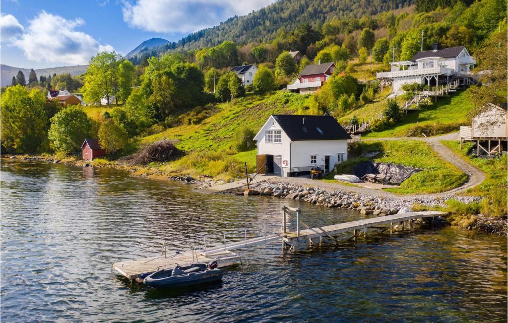 a boat is docked at a dock on a lake at Beautiful Apartment In Vestnes With House A Mountain View in Vestnes