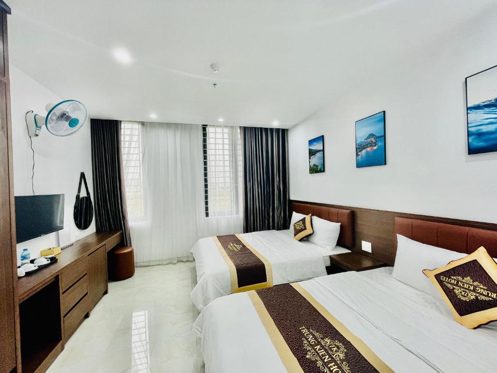 Habitación de hotel con 2 camas y TV de pantalla plana. en TRUNG KIÊN HOTEL en Ha Long