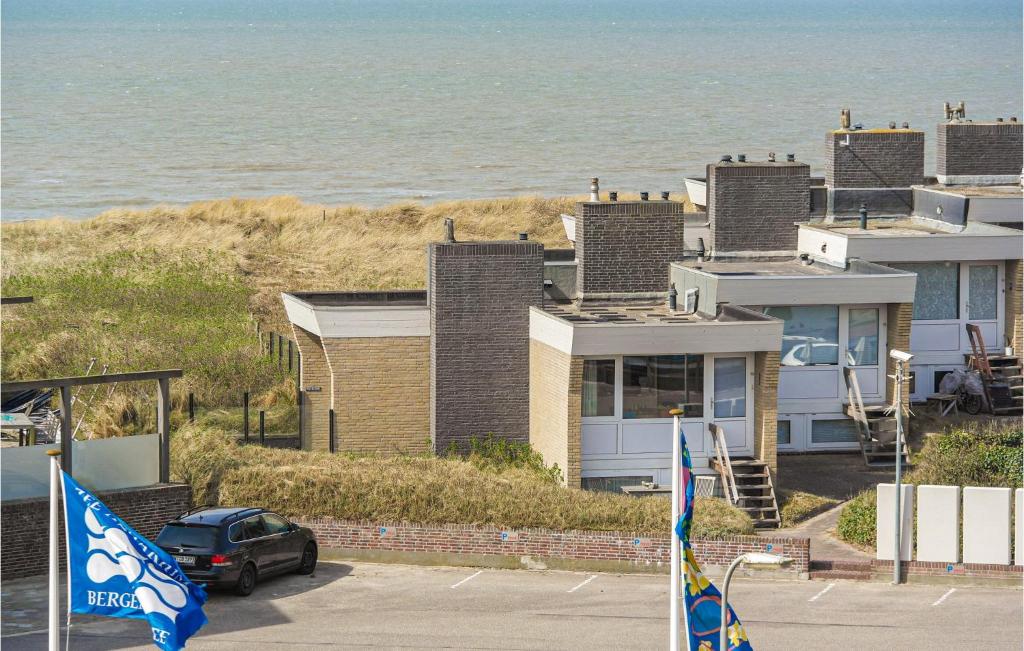 a car parked in front of a house next to the ocean at De Trapjes in Bergen aan Zee
