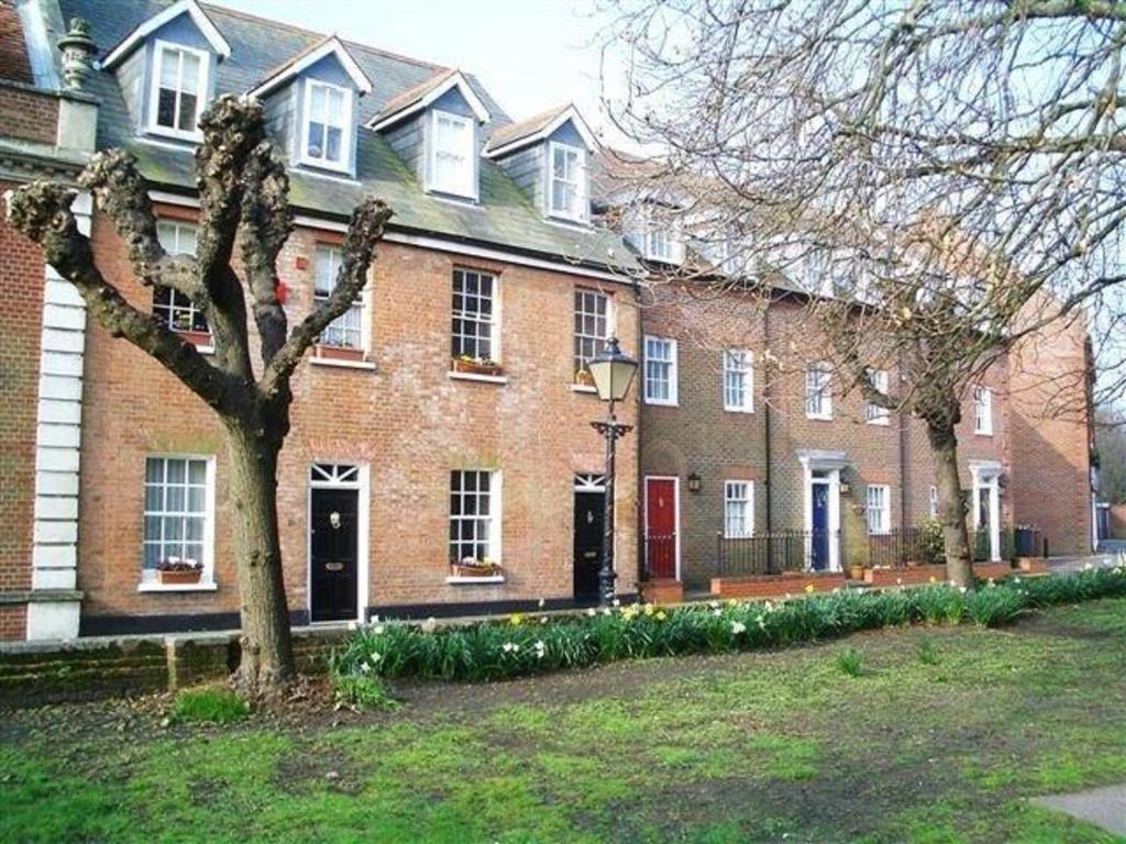 un gran edificio de ladrillo con un árbol delante de él en Quayside Quarters, en Poole