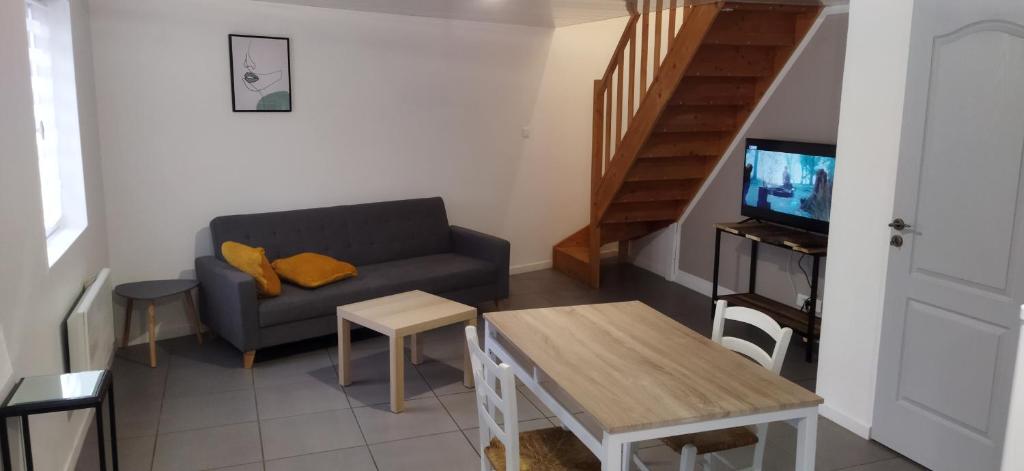un soggiorno con divano, TV e tavolo di Appartement en duplex à Hébuterne, avec lave linge a Hébuterne