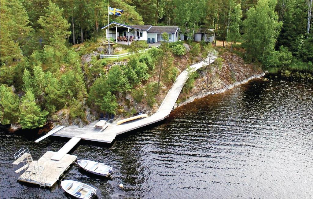 a house on a dock in the water with boats at Awesome Home In rjng With 3 Bedrooms And Wifi in Östra Viker