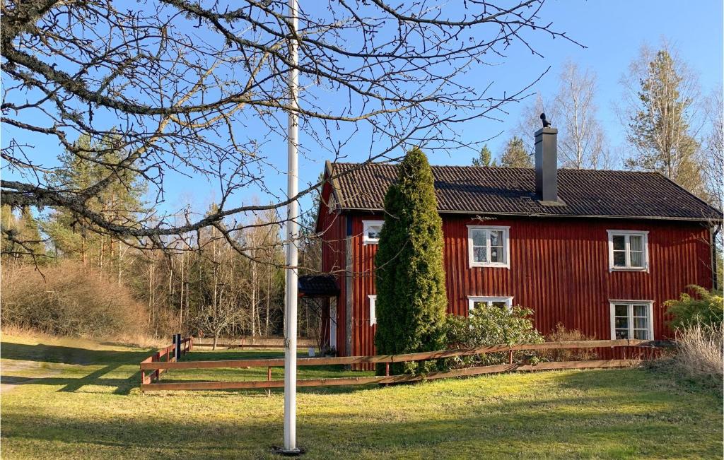 czerwony dom z kijem przed nim w obiekcie 3 Bedroom Awesome Home In Vstervik w mieście Västervik