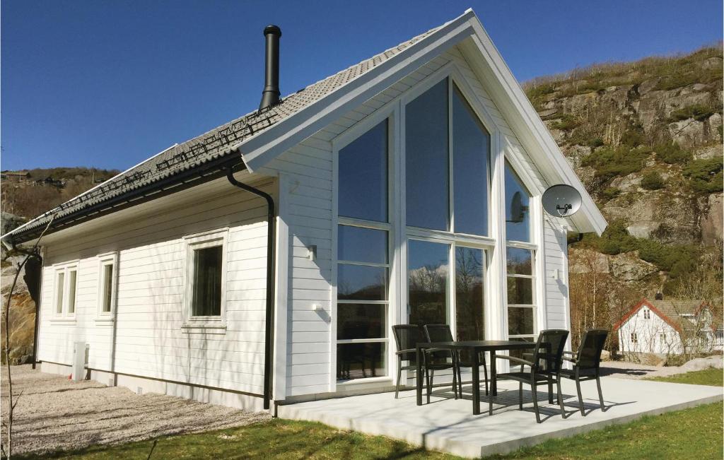 ein Haus mit einem Tisch und Stühlen davor in der Unterkunft Beautiful Home In Lyngdal With Kitchen in Lyngdal