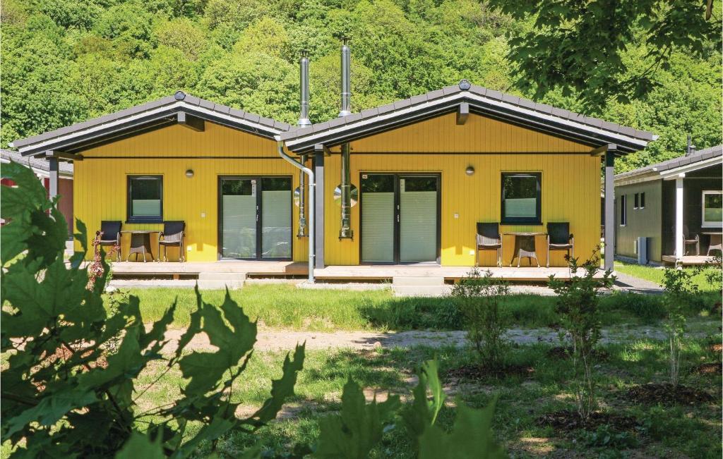 a yellow house with tables and chairs in a yard at Ferienhausdorf Thale in Thale