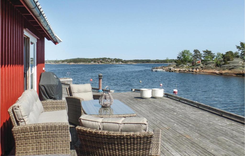 a wooden deck with chairs and a table on the water at Havtunet in Trolldalen