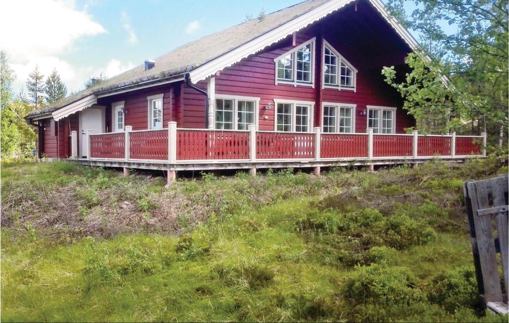 a red house with a porch on a hill at Awesome Home In Slen With 4 Bedrooms, Sauna And Wifi in Stöten