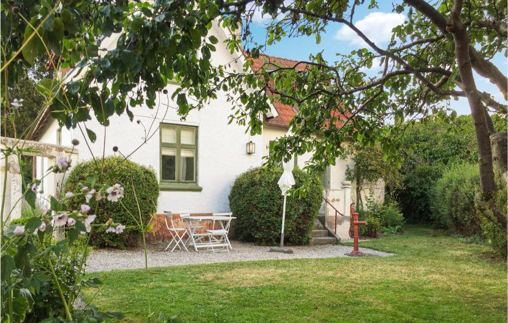 ein weißes Haus mit einem Tisch und Stühlen im Hof in der Unterkunft Amazing Home In Abbeks With House Sea View in Abbekås