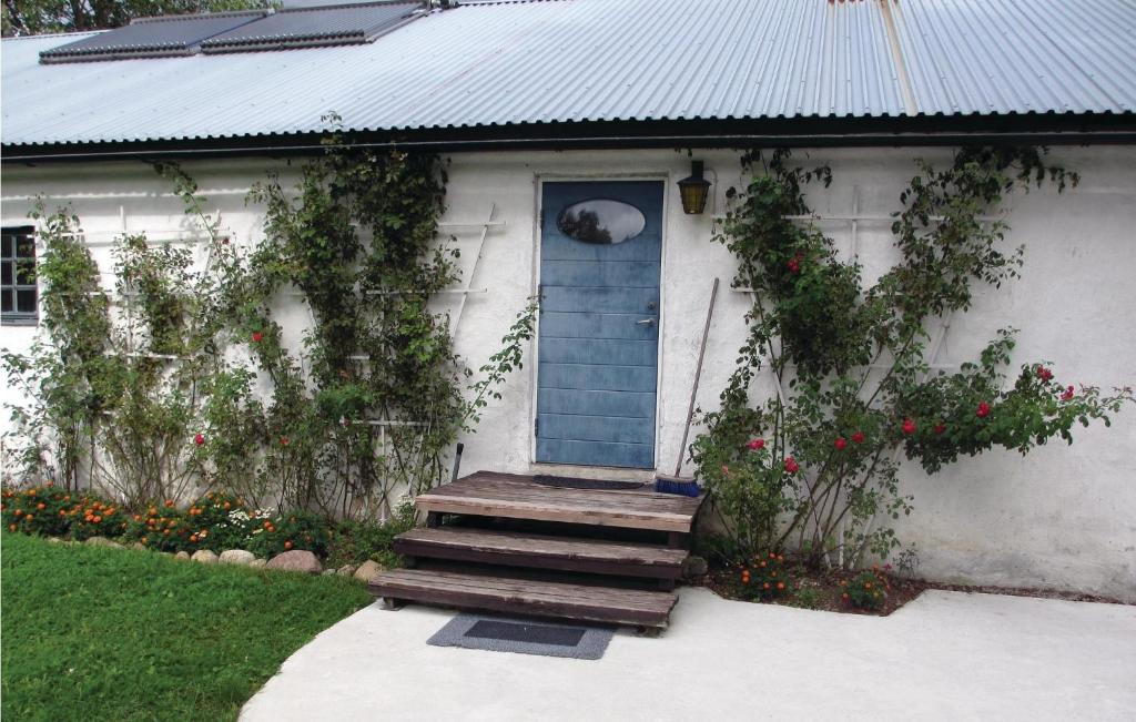 a white house with a blue door and stairs at Nice Home In Visby With Wifi in Endre