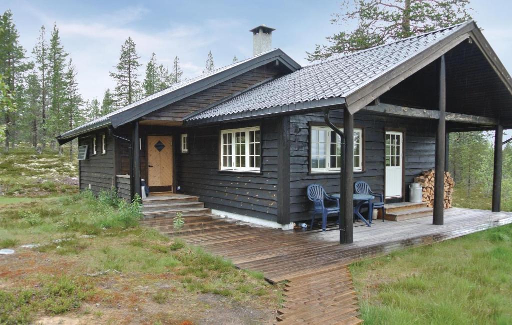 Cabaña de madera con terraza y mesa en Awesome Home In Rendalen With House A Mountain View, en Akrestrommen