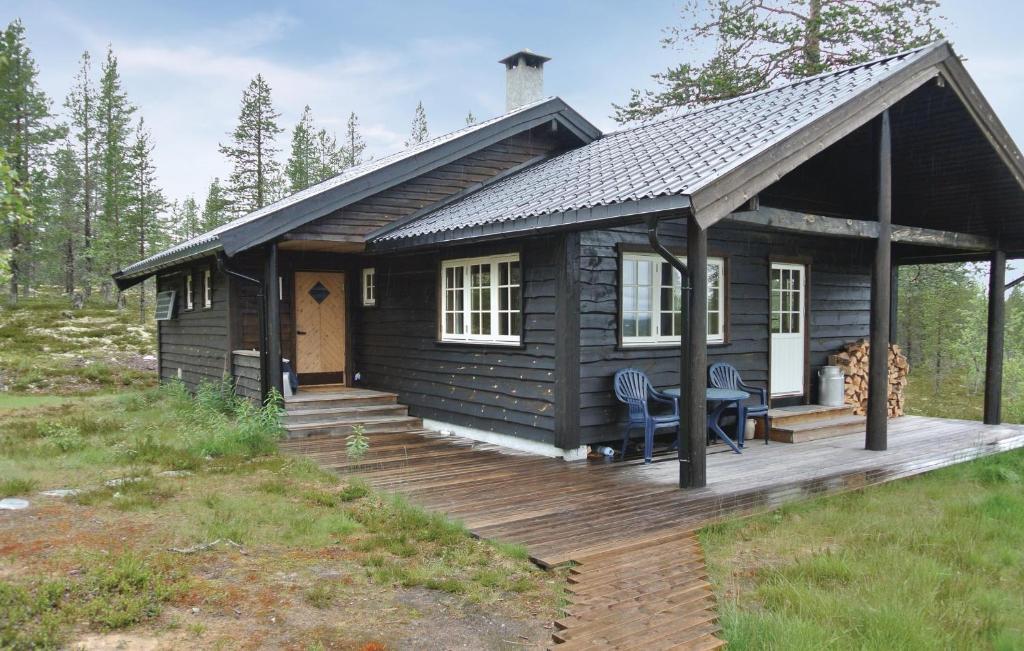 a log cabin with a deck and a table at Cozy Home In Rendalen With Sauna in Akrestrommen
