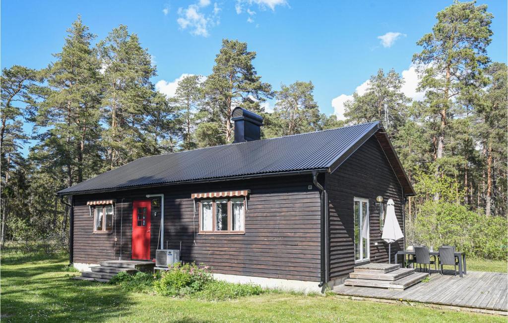 a small black cabin with a red door at Lovely Home In Lrbro With Kitchen in Ire