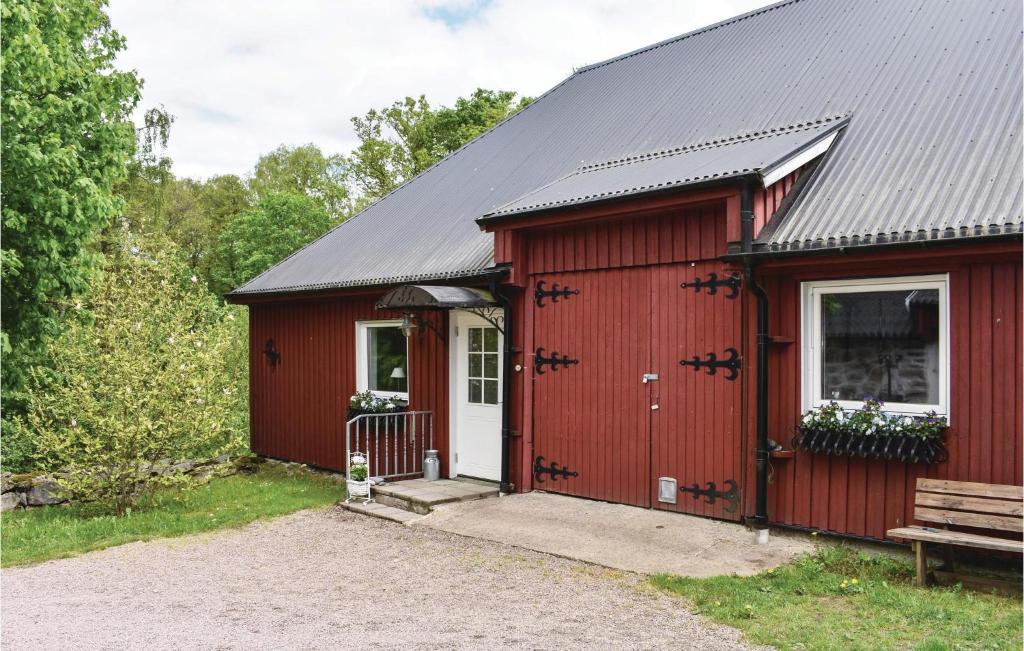 un abri rouge avec une porte blanche et une véranda dans l'établissement Cozy Apartment In Tjrnarp With House A Panoramic View, à Tjörnarp