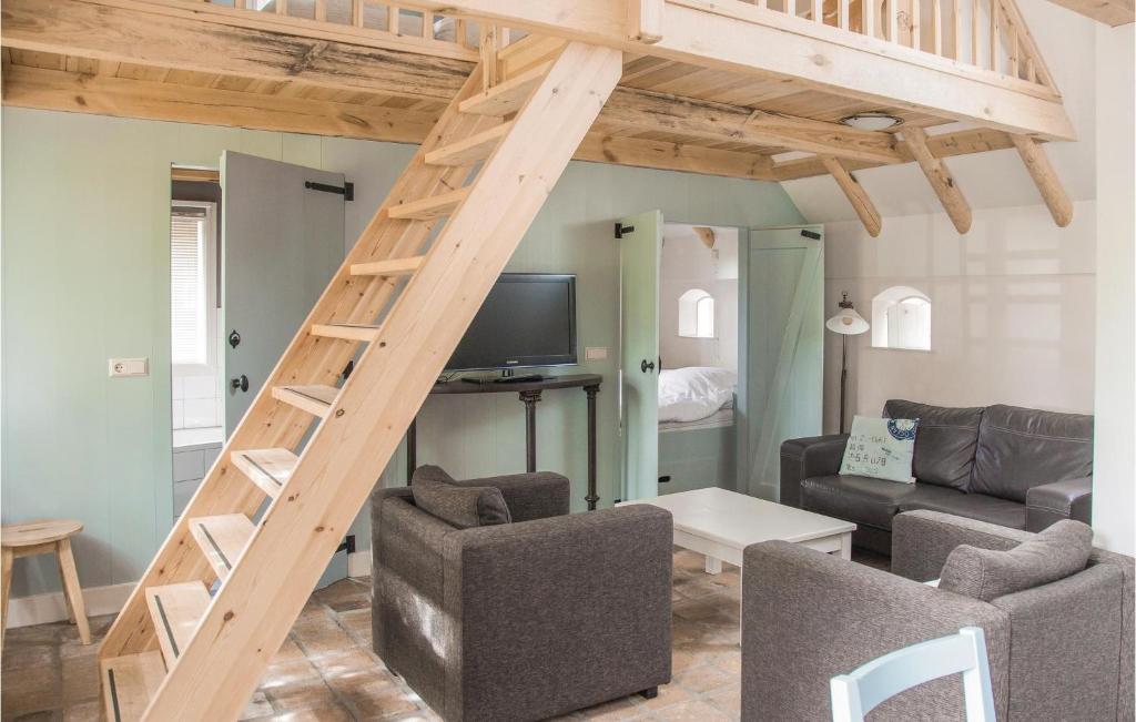 a living room with a loft with a ladder at Het Vissershuisje in Wijdenes