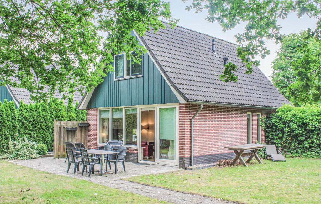 een huis met een tafel en stoelen in de tuin bij Beautiful Home In Winterswijk With 3 Bedrooms And Wifi in Winterswijk