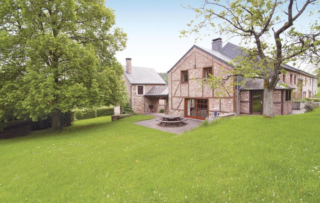 a large brick house with a yard with a grass field at La Maison D'albertine in Briscol