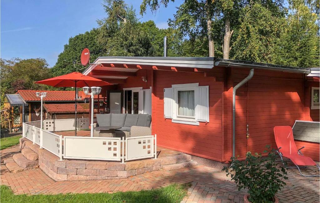 una casita roja pequeña con patio y sombrilla en Stunning Home In Staufenberg With Wifi, en Staufenberg