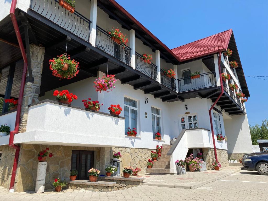 a white building with flowers on the balconies at Pensiunea Boculeț Gura Humorului in Gura Humorului