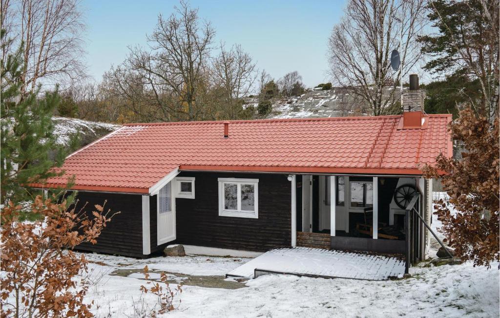 ein kleines Haus mit orangefarbenem Dach im Schnee in der Unterkunft Stunning Home In Hjlteby With Kitchen in Hjälteby