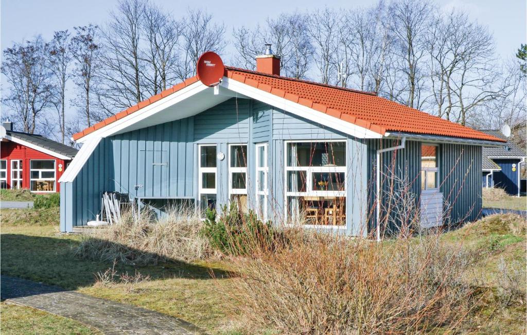 a blue house with an orange roof on a field at Freibeuterweg 5 - Dorf 6 in Priwall