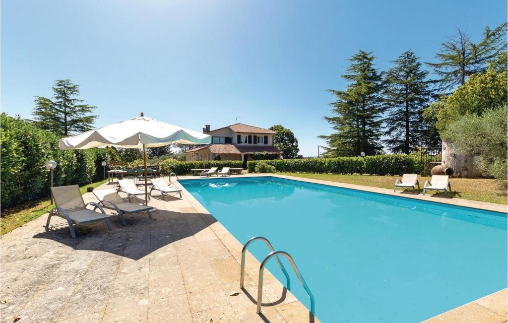 a swimming pool with chairs and an umbrella at Tenuta Aliano in Corchiano