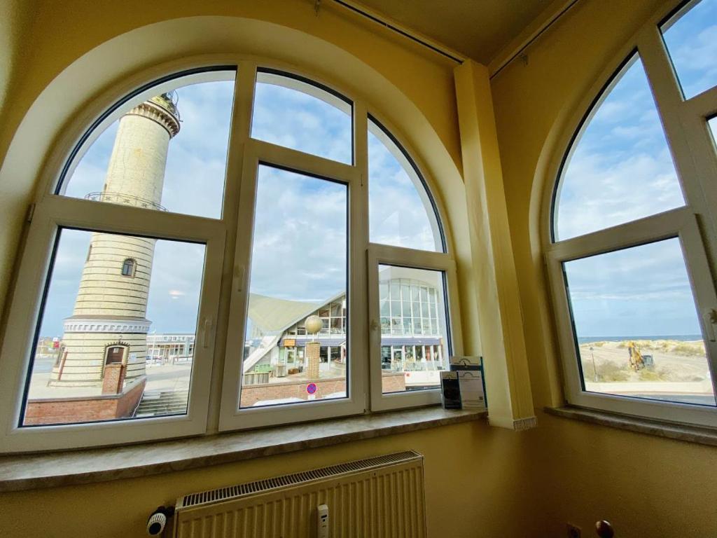 una vista su un faro da una camera con finestre di Promenadenblick/Captains-Suite a Warnemünde
