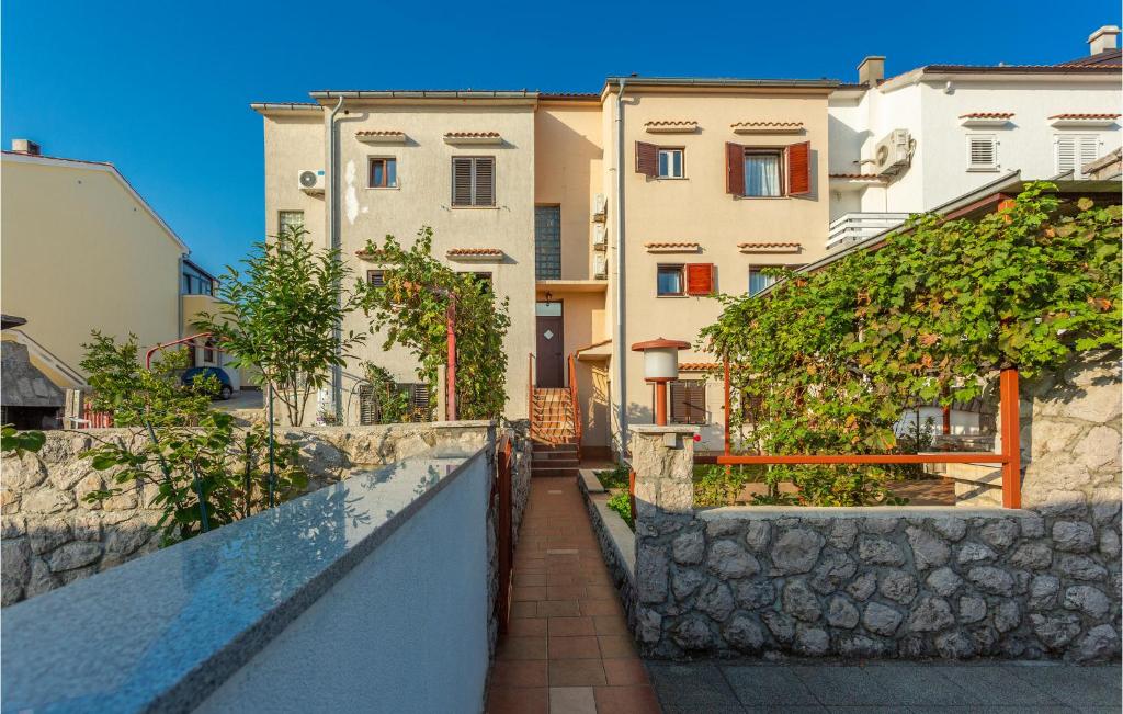 a walkway leading up to some buildings with a wall at 3 Bedroom Lovely Home In Omisalj in Omišalj