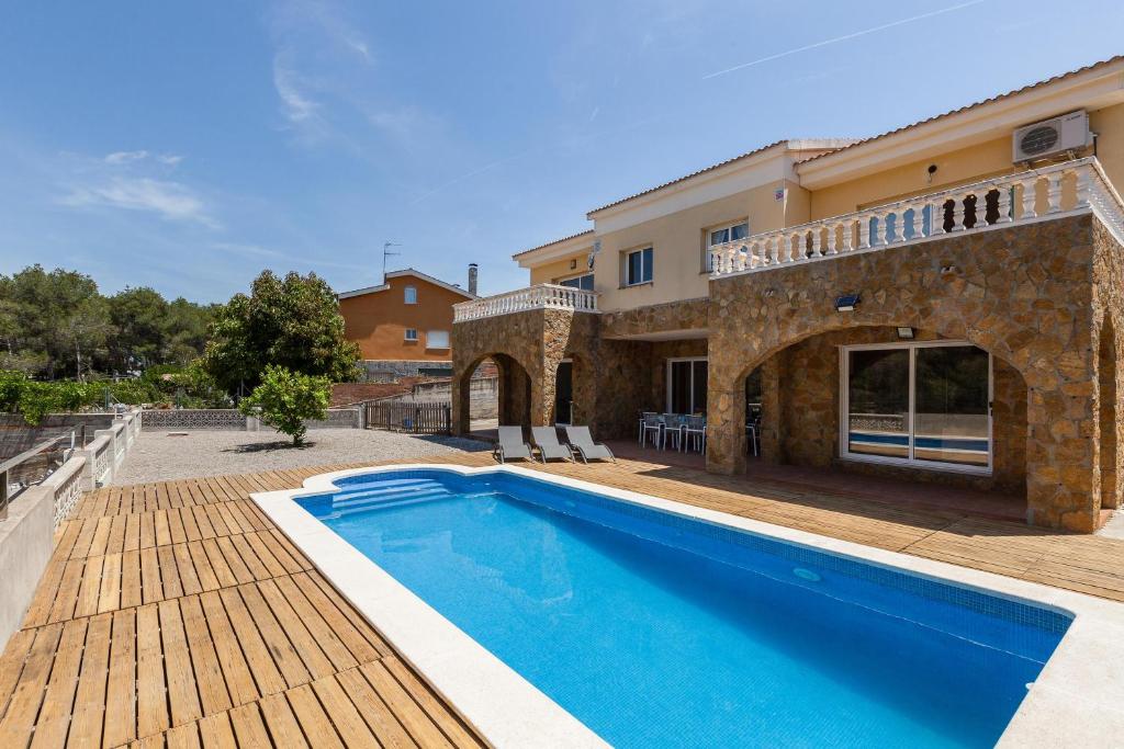 a villa with a swimming pool and a house at Villallop in Olivella