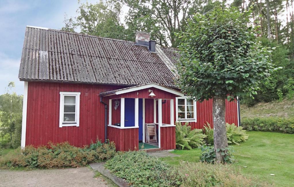 una casa roja con una puerta blanca y un árbol en 2 Bedroom Lovely Home In Knred en Timmerhult