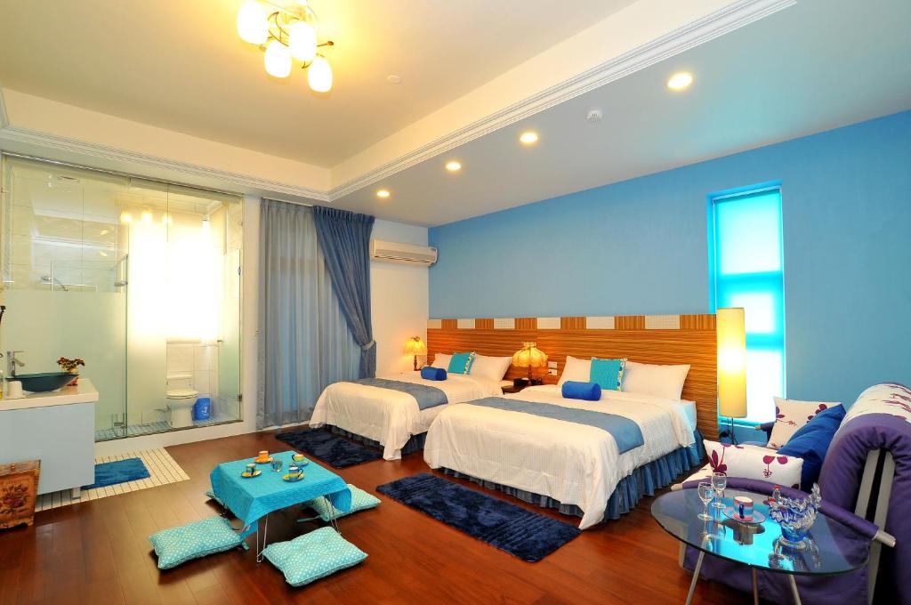 a bedroom with two beds and a living room at Jing Xiang Hua Nong B&amp;B in Dongshan