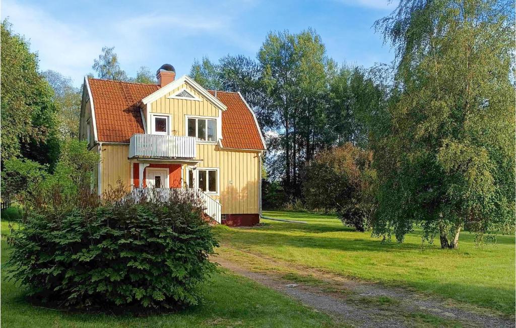 a yellow house with a red roof on a field at Holiday Home Sandsjöfors 47 in Holsteryd