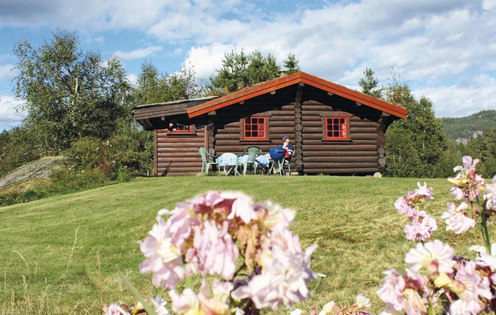 a log cabin with tables and chairs in front of it at 2 Bedroom Cozy Home In mli in Støylen