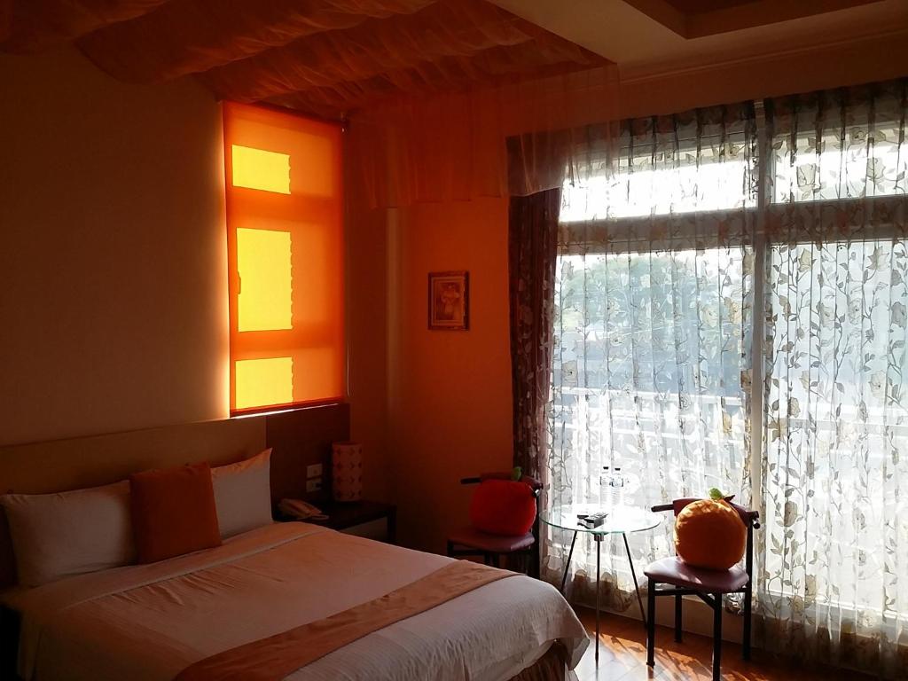 a bedroom with a bed and a window at Jing Xiang Hua Nong B&amp;B in Dongshan