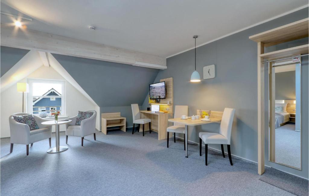 uma sala com mesas e cadeiras e um quarto em Cozy Apartment In Dagebll With Kitchenette em Dagebüll