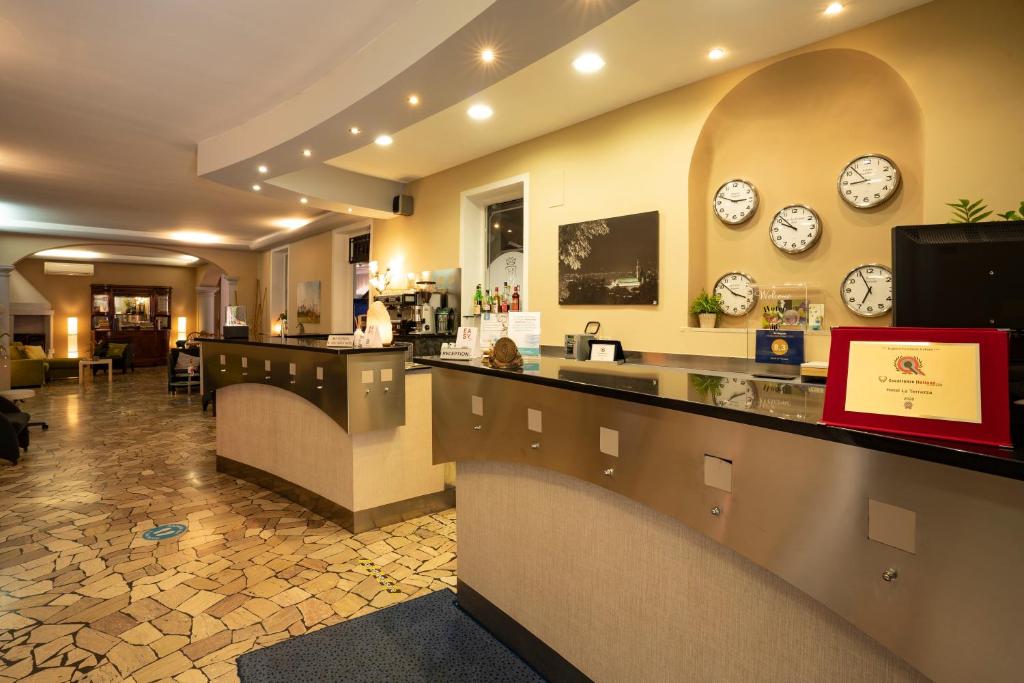 un restaurant avec des horloges sur le mur et un comptoir dans l'établissement Hotel La Terrazza, à Vicence