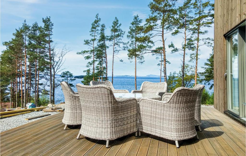 a group of wicker chairs sitting on a deck at 3 Bedroom Amazing Home In Jørpeland in Jørpeland