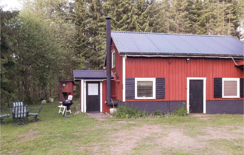 ein rotes Haus mit einer Bank davor in der Unterkunft Awesome Home In Holsljunga With Kitchen in Holsljunga