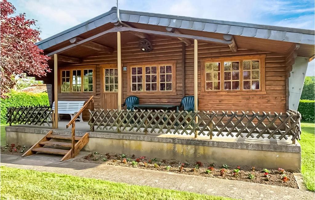 une cabane en rondins avec une terrasse couverte et 2 chaises dans l'établissement Mamet, à Waldbillig