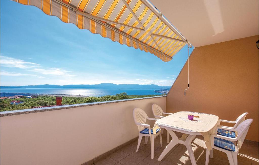 a balcony with a table and chairs and a view of the ocean at Amazing Apartment In Smrika With Wifi in Šmrika