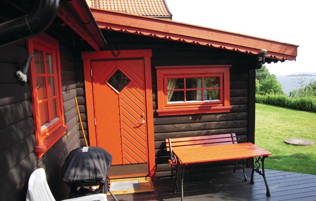 a cabin with a table and a bench on a deck at Stunning Home In sgrdstrand With Wifi in Åsgårdstrand