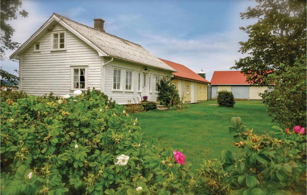 une vieille maison blanche avec une cour fleurie dans l'établissement Beautiful Home In Vanse With Kitchen, à Vanse