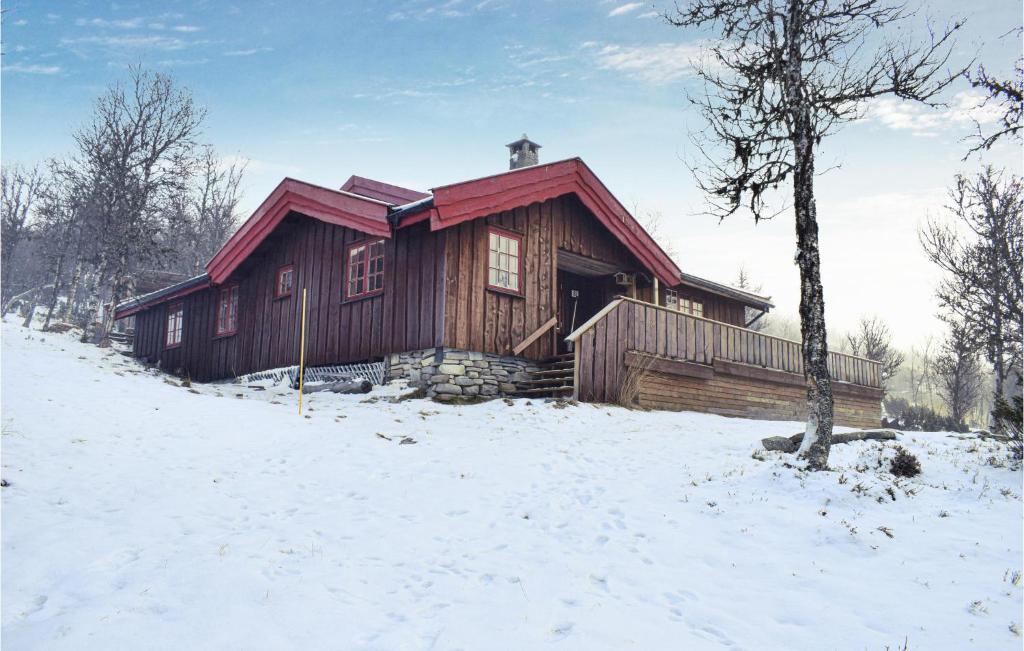 een blokhut in de sneeuw met een boom bij Beautiful Home In Venabygd With House A Mountain View in Venabygd