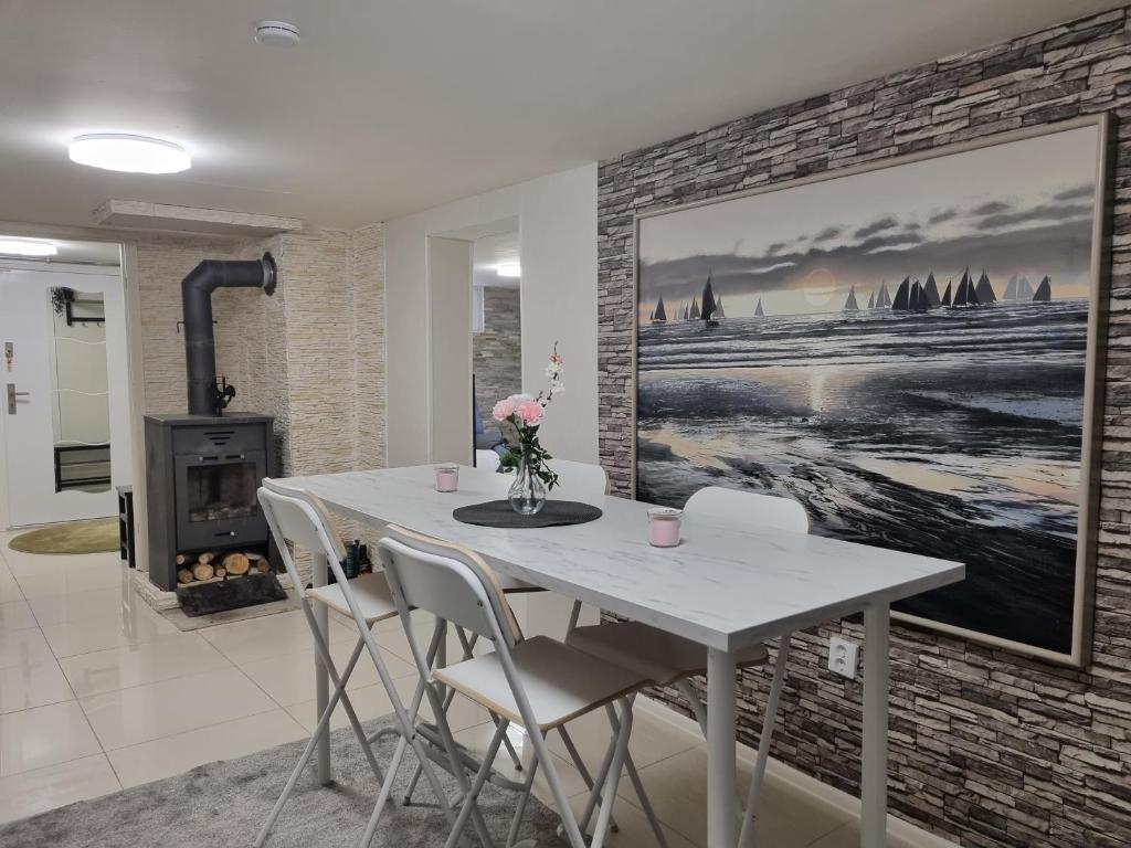 a dining room with a white table and a fireplace at Moonlight - Trevlig Källarlägenhet in Broby