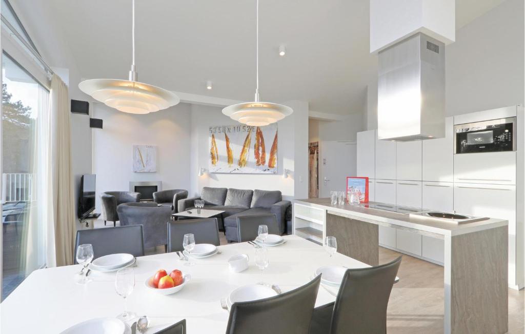 een keuken en eetkamer met een witte tafel en stoelen bij Dnenvilla Penthouse in Travemünde