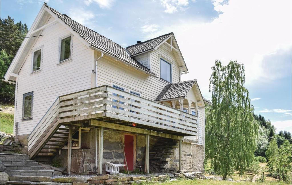 an old house with a wooden porch and a tree at 4 Bedroom Beautiful Home In Steinstø in Steinstø