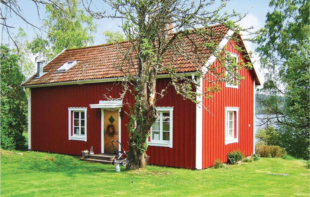 Uma casa vermelha com um cão à frente. em Beautiful Home In Eksj With House Sea View em Hult