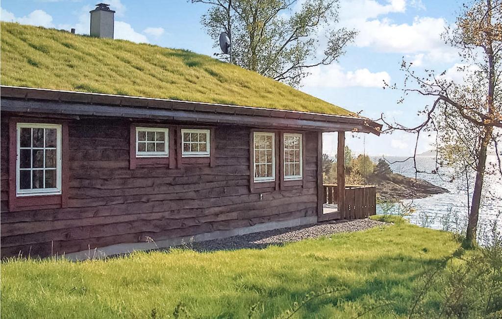 una pequeña casa con techo de hierba en un campo en Eikhaugen Gjestegard, en Vinnes